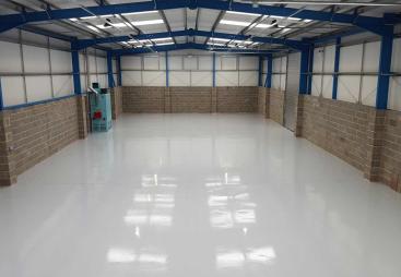 An interior view of an empty warehouse with an epoxy resin floor