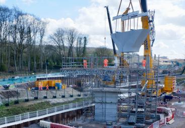 A concrete Y shaped block being lifted by a crane for a new railway viaduct