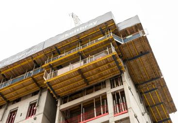The top of an under construction building surrounded by yellow formwork