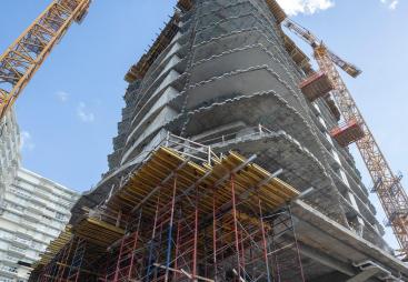 A high rise under construction with yellow formwork 