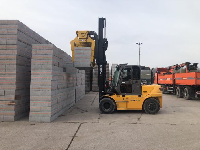 A yellow forlift stacking concrete plinths