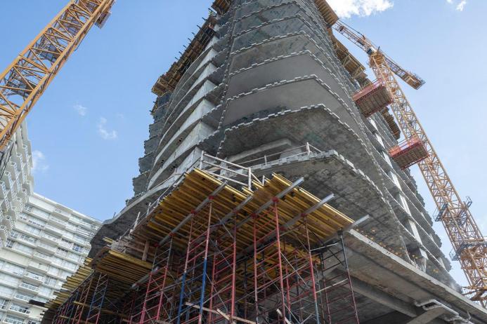 A high rise under construction with yellow formwork 