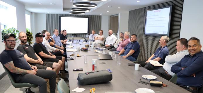 A group of men sitting round a board table