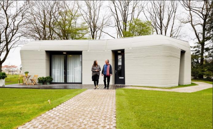 Two people walking down the garden path from a single story house