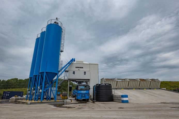 A concrete plant with three blue silos