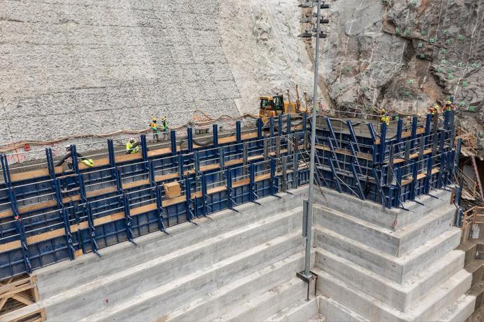 Blue formwork being sued to construct a concrete RCC dam