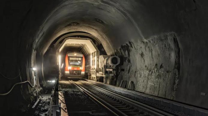 Inside a rail tunnel with a red engine