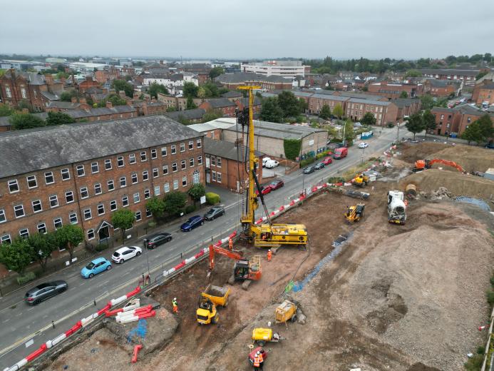 An aerial view of a housing development under construction with a yellow piling rig and other assorted plant.