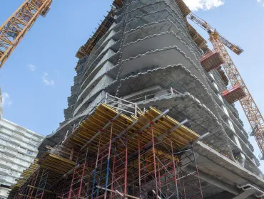 A high rise under construction with yellow formwork 