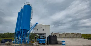 A concrete plant with three blue silos