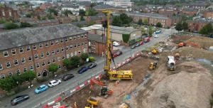 An aerial view of a housing development under construction with a yellow piling rig and other assorted plant.