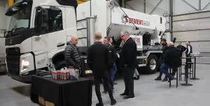 A group of men socialize in front of a volumetric concrete mixer at Volumetric's first Christmas open day was held at its new facility in Wednesbury, in the West Midlands. 