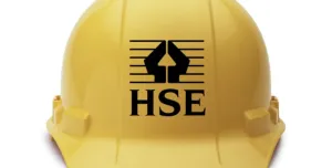 A yellow hard hat with the HSE logo in black on its front