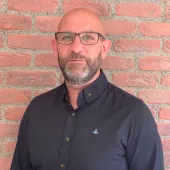 A man standing in front of a brick wall