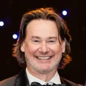 Head a shoulders of a man smiling wearing a tux and bowtie