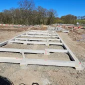 Concrete beams lying on the ground at a construction site