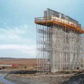 A bridge pier under construction covered in scaffolding