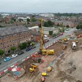 An aerial view of a housing development under construction with a yellow piling rig and other assorted plant.