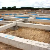 Concrete foundation beams for houses laid out on a construction site