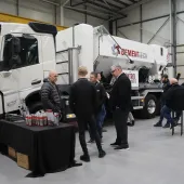 A group of men socialize in front of a volumetric concrete mixer at Volumetric's first Christmas open day was held at its new facility in Wednesbury, in the West Midlands. 