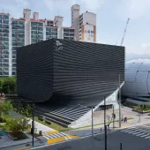 An exterior view of the Photography Seoul Museum of Art (Photo SeMA) features a distinctive twisted silhouette, created using a rhythmic layering of angled precast concrete panels.