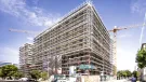 An under construction mid-rise building covered in scaffolding