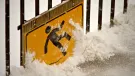 A health and safety sign of a person slipping on ice, covered in snow