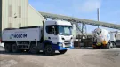 A white, Holcim branded truck at a cement works.