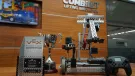 The Vex Robotics Awards on a table in front of a Combilift sign and video display showing a yellow and blue robotic vehicle